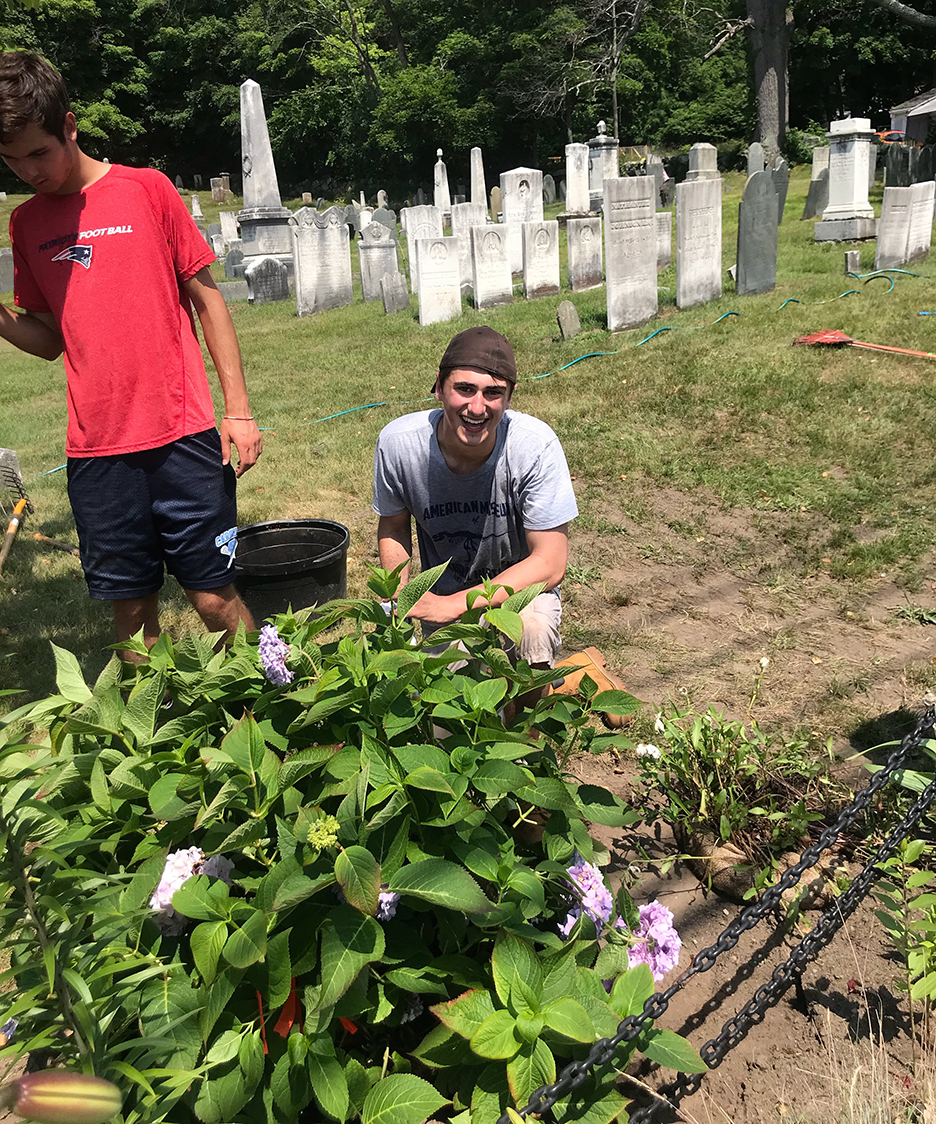 Boy Scout Lucas Pocher, shown, sought an Eagle Scout project and got a lot of cooperation from family members, volunteers, the Downtown Marigold Project, Holliston in Bloom, Ahronian Landscape and even the Holliston Highway Department to make a beautiful addition to the Central Burying Ground at Holliston Town Hall. Photos by Mark Ahronian