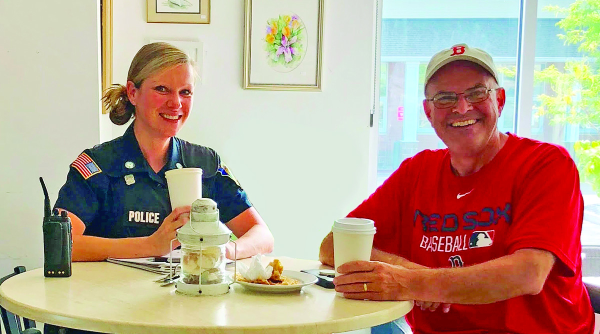 Detective Michelle Palladini, visiting with a retired Walpole police officer, during a recent Coffee with a Cop event at Cilla’s Coffeehouse.