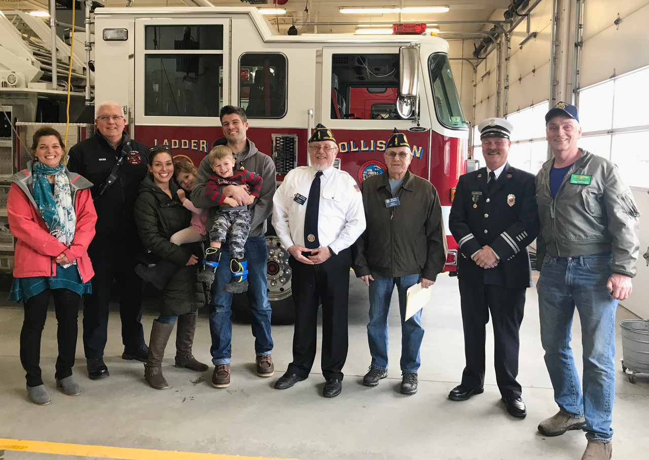 U.S. Army Reserve 2nd Lt. Mitchell Gannon is joined by his family, members of Holliston American Legion Post 47, and members of Holliston Fire Department, as the Legion awards him the Medal of Merit for his lifesaving action while off duty at Logan Airport. From left, Kriss Westland, Lt. Brian Grace, Joanna Gannon holding Heidi Gannon, Mitchell Gannon holding John Gannon, Stephen Bradford, Walter McGrath, Capt. John E. Gagnon, and Pete Westland.