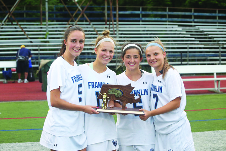 Franklin’s senior captains, displaying last year’s trophy after winning the East Sectional championship against Acton-Boxboro, include, from left, Kendall Reardon, Caroline Lounsbury, Dana Lewandowski, and Grace McDermott.   