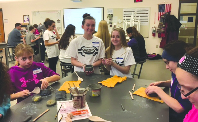 Franklin High School Empty Bowls Club students (standing, left to right), Julia Mahon and Jess Netto, helped participants in a recent Empty Bowls Project event make clay bowls in preparation for the 2nd Annual Empty Bowls Dinner on May 2 at Franklin High School.