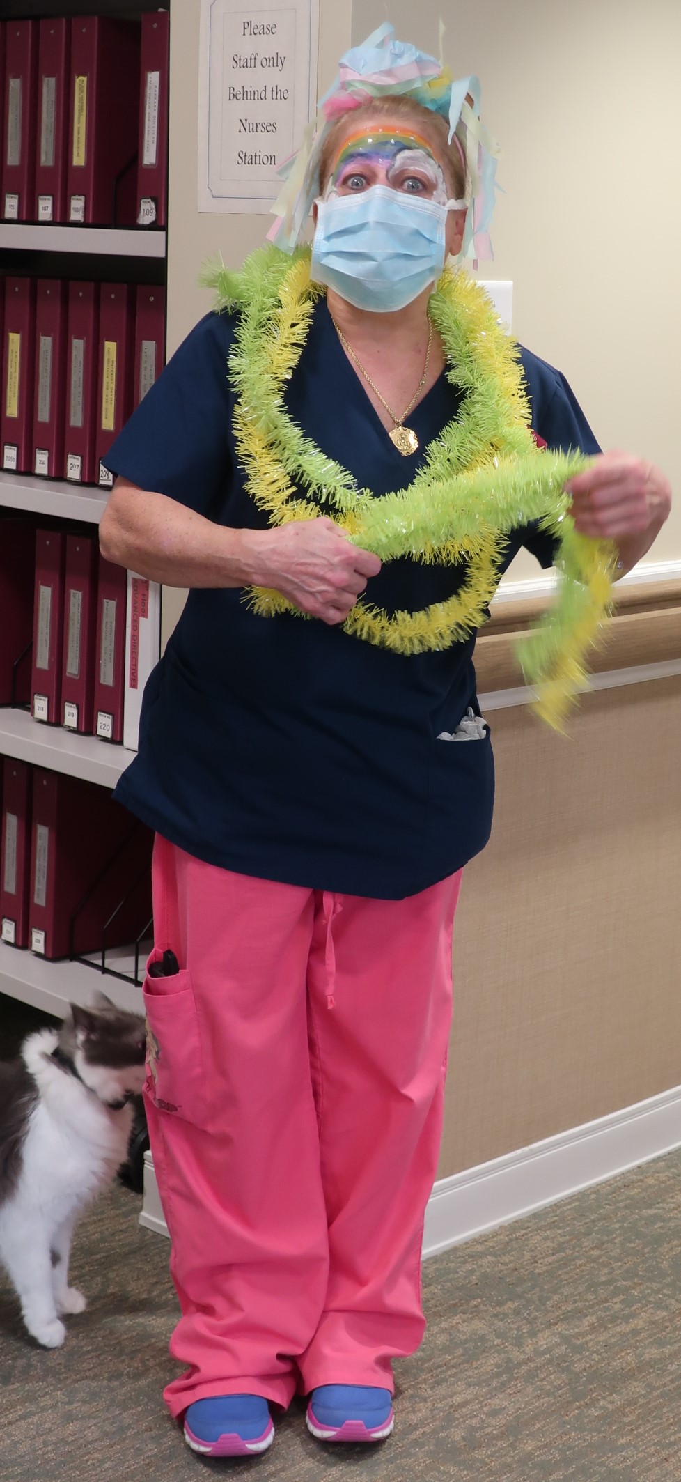 Each week the staff have a theme day to bring smiles to the residents who, for safety reasons are required to stay in their rooms much of their day – here is Certified Nursing Assistant Nanci Rando who is showing off her fabulous choice of decoration for Rainbow Day