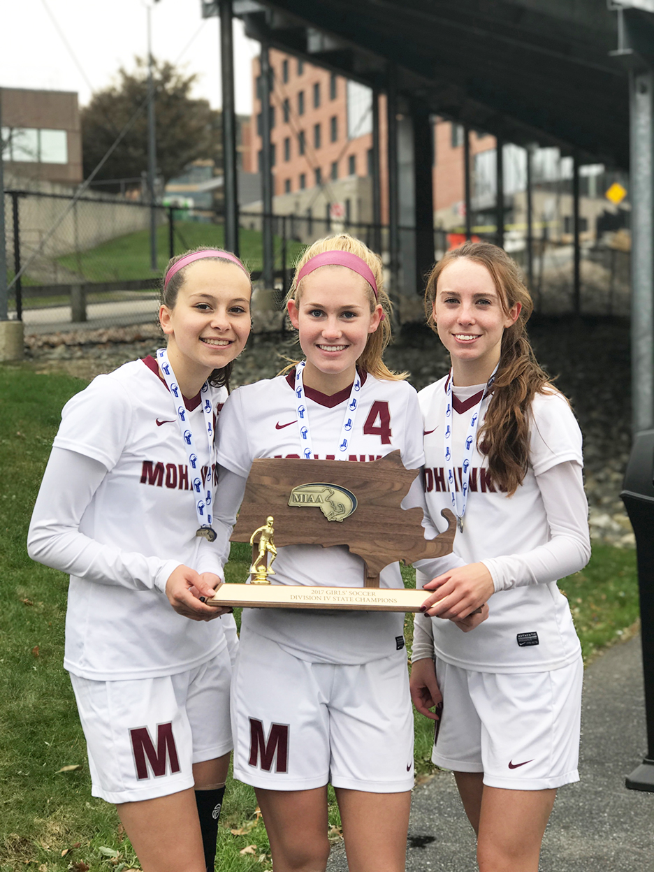 Millis Soccer Captains Riley Donovan, Jess Krauss and Caira Moynihan are shown here with their team’s state championship plaque. This year, having graduated nine seniors last year, the team is starting from scratch defending the title.