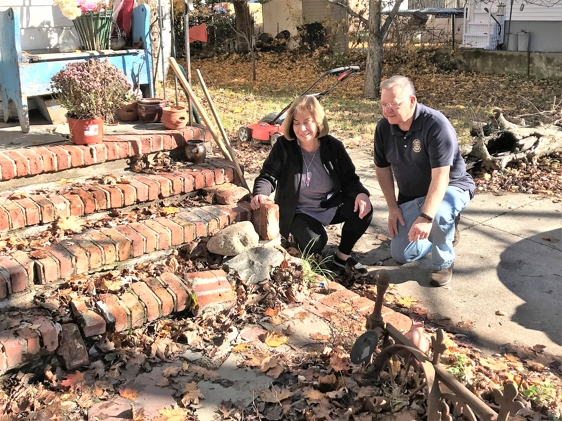 Susan Wells and Ken Erdelt examine an elderly Ashland family’s crumbling steps, which are being repaired thanks to the Framingham Rotary Club. (Photo/supplied)